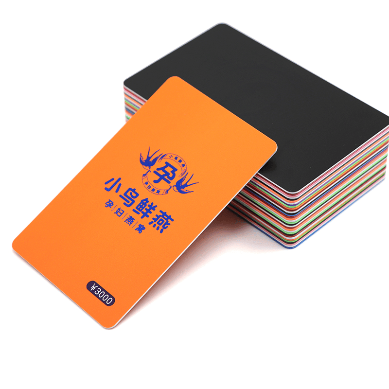 Narandžasta mat PVC kartica na gomili kartica sa crnim jezgrom prikazuje izdržljivu mat laminaciju i precizno obrađene ivice.
