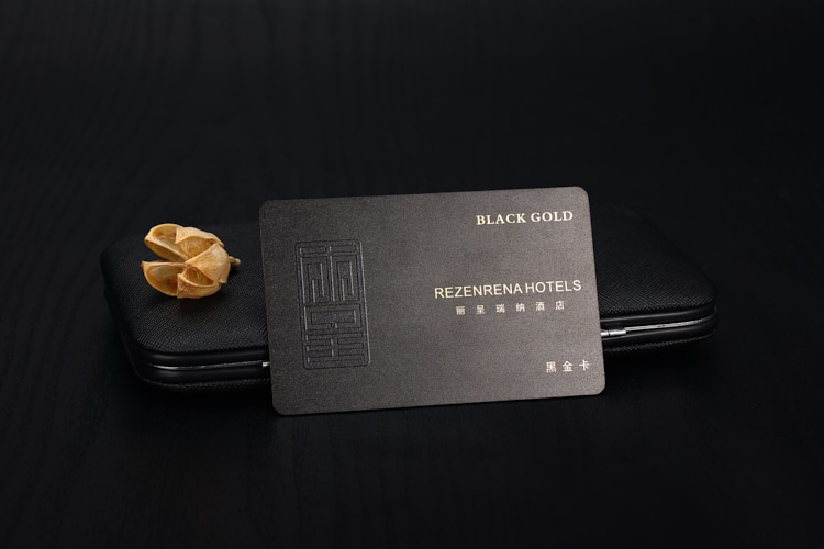 Crno-zlatna plastična VIP kartica za hotelsko članstvo prikazana sa rekvizitom na tamnoj pozadini kako bi se naglasio luksuzni brending u ugostiteljstvu.