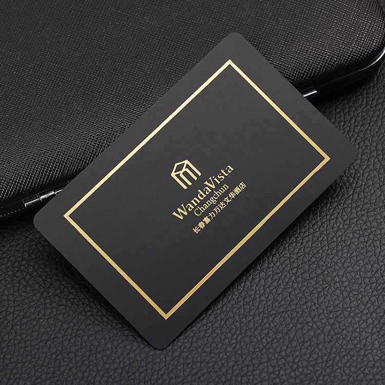 Minimalistička crna plastična VIP kartica sa tankim zlatnim okvirom i logotipom u sredini prikazana na koži radi prikaza čistog luksuznog brendiranja.