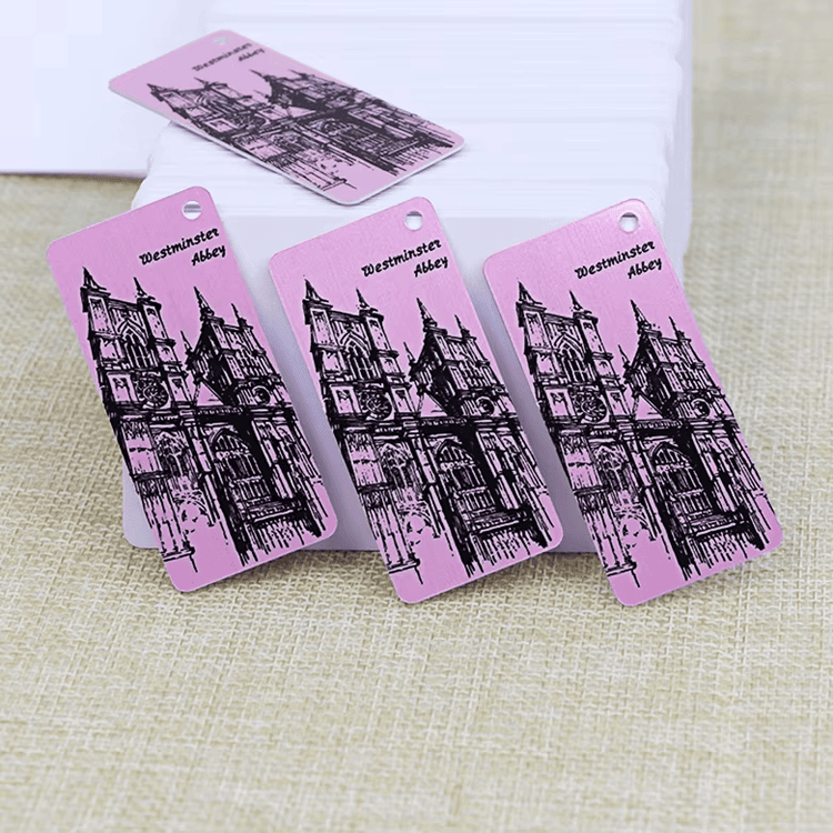 Roze plastični combo privjesci za ključeve sa ilustracijom zgrade i probušenim rupama prikazani su za nošenje pri korporativnom pristupu zaposlenih.