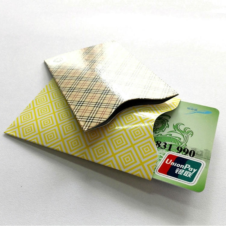 Karirana RFID zaštitna futrola na žutoj futroli s delimično umetnutom bankovnom karticom prikazuje pristajanje u držaču vizitkarti i zaštitu od skeniranja.