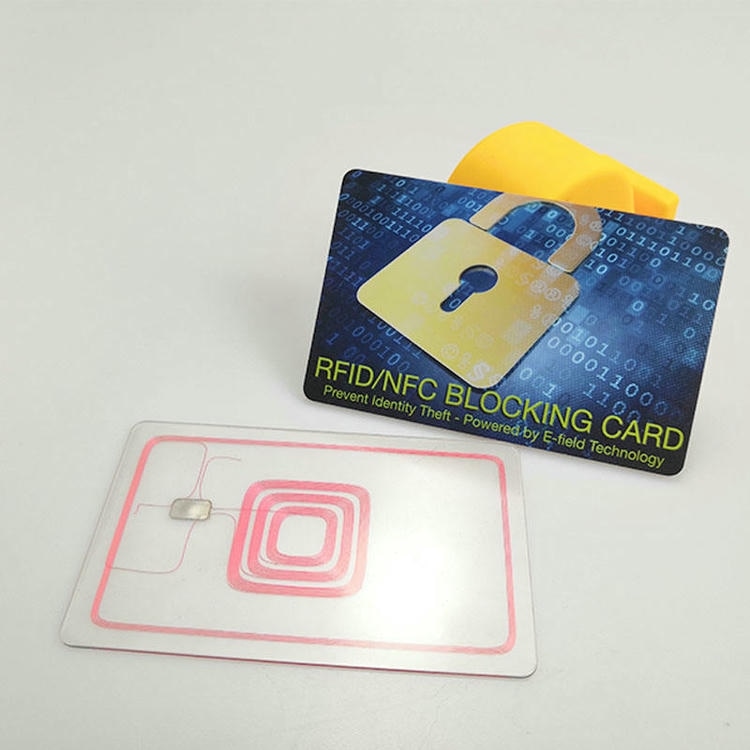 Štampana RFID zaštitna kartica sa motivom katanca prikazana je pored prozirne kartice sa ugrađenom antenom radi objašnjenja zaštitnog sloja u kartici.