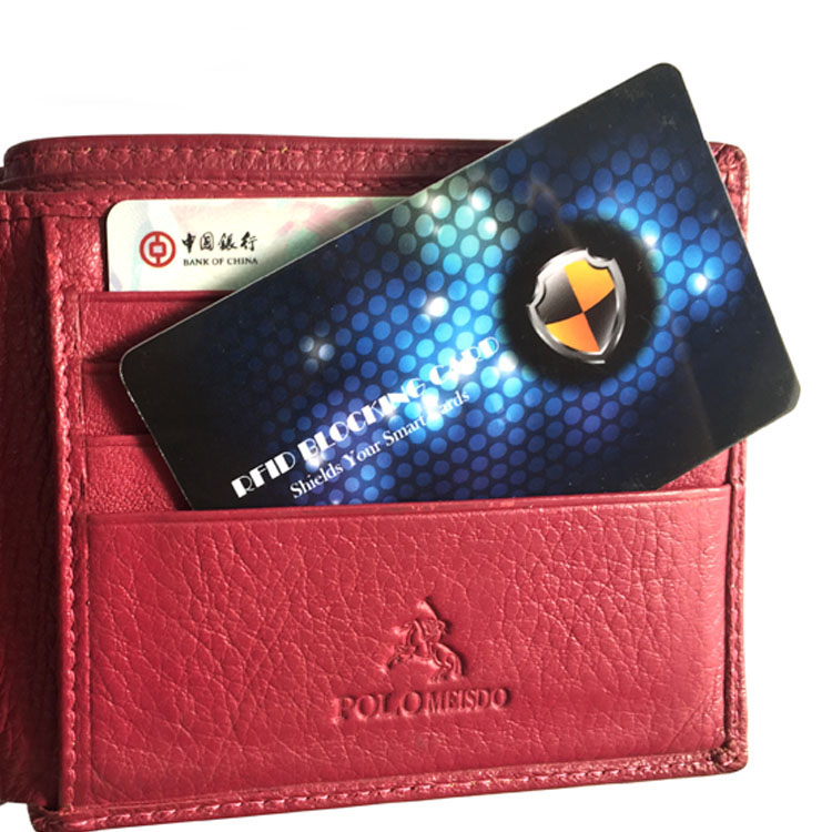 RFID zaštitna kartica je postavljena u džep crvenog kožnog novčanika iznad bankovne kartice da bi se prikazala sigurnost beskontaktnog plaćanja.