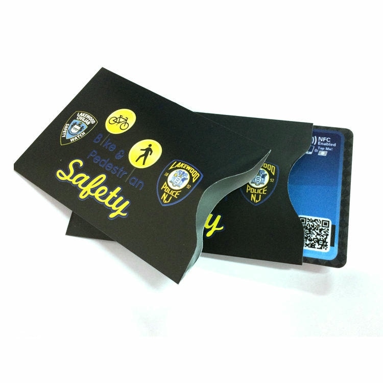 RFID zaštitna futrola sa štampom po meri na temu bezbednosti drži plavu NFC karticu s QR kodom i prikazuje zaštitu beskontaktnih ID kartica.