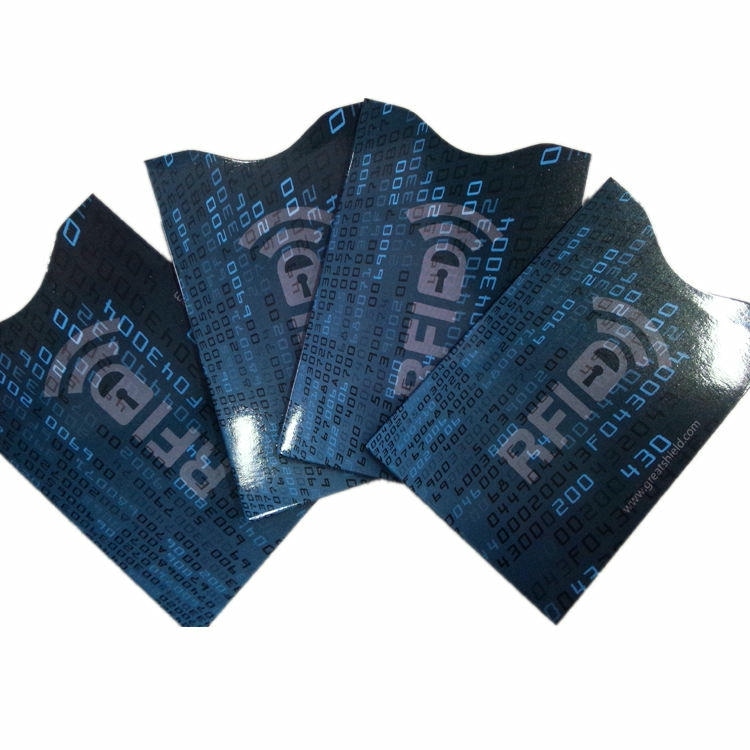Četiri plave RFID zaštitne futrole u stilu GreatShield lepezasto su raspoređene radi prikaza sjajnog kodnog uzorka i zakrivljenog otvora za palac.