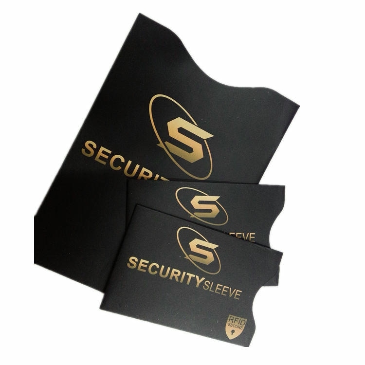Crne RFID zaštitne futrole Security Sleeve sa zlatnim logotipom naslagane su uz odgovarajuću veliku futrolu radi prikaza usklađenog brendiranja za zaštitu novčanika.