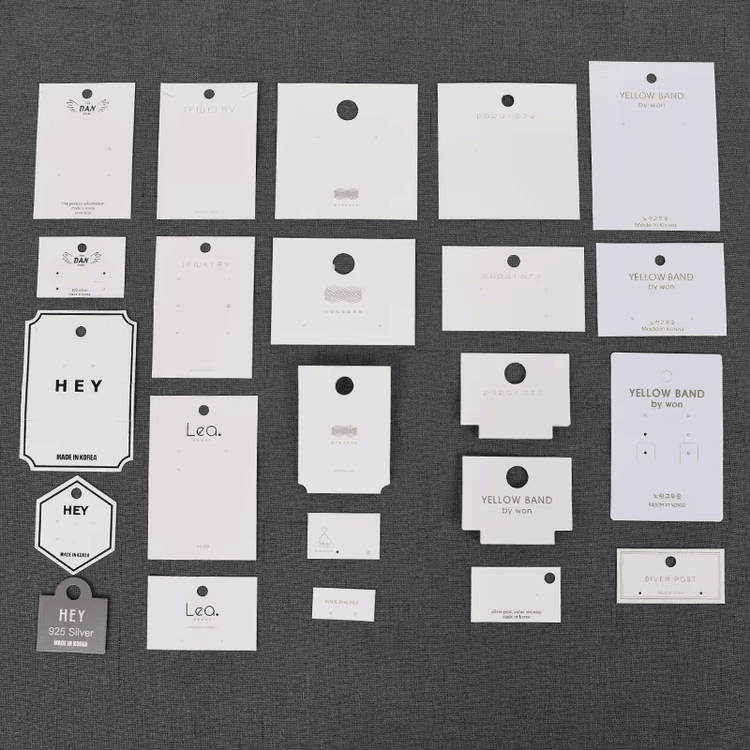 Minimalistička bela papirna viseća etiketa sa čistom tipografijom koja predstavlja moderan i suptilan estetski izraz za brendove održive odeće
