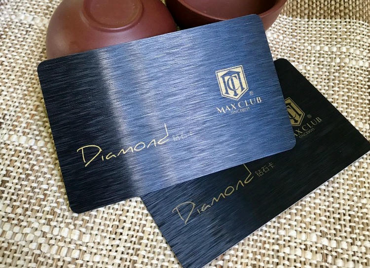 Prefinjena brušena tamnoplava plastična kartica ima preklapajuće dizajne sa zlatnim tekstom Diamond i Max Club logotipom na teksturiranoj metalnoj površini.