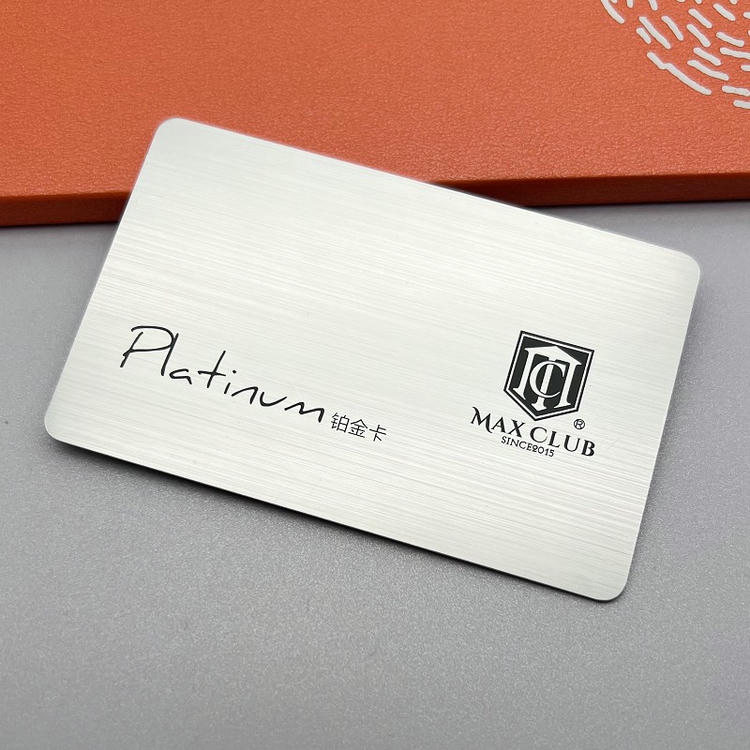 Krupni plan srebrne brušene plastične kartice ističe linearnu metaliziranu teksturu sa brendom Max Club i oznakom Platinum za prefinjeno članstvo.