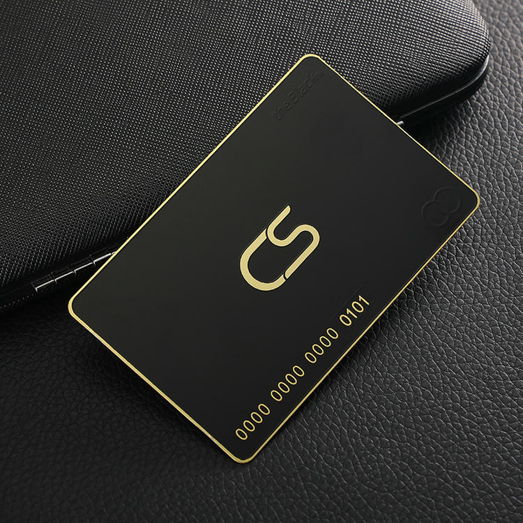 Crna luksuzna metalna VIP vizitkarta sa zlatnom ivicom i logotipom u sredini leži na teksturiranoj koži za programe lojalnosti visoke klase.
