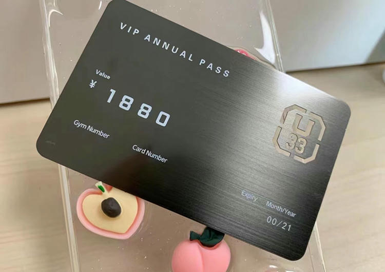 Crna luksuzna VIP metalna poslovna karta dizajnirana kao godišnja propusnica, prikazana na rekvizitima na stolu radi ilustracije izdržljivog stila članskih akreditiva.