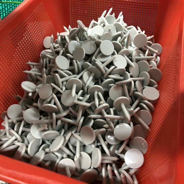 Ova slika prikazuje korpu napunjenu belim NAIL06-6 RFID nokat oznakama u rasutom stanju za fabričko sortiranje, pakovanje ili inspekciju.