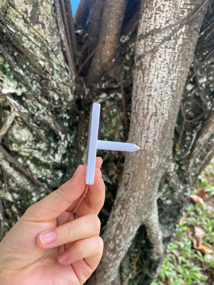 Ova slika prikazuje ruku koja drži beli NAIL06-7 RFID ekser tag pored drveta kako bi se prikazao bočni profil i oblik instalacije.