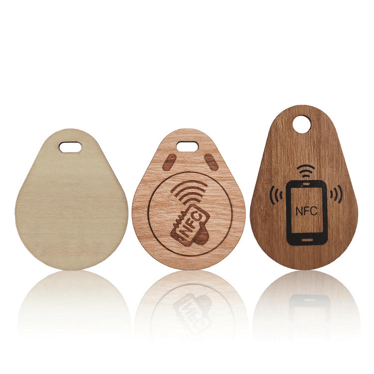 Upareni drveni RFID privjesci za ključeve prikazuju NFC oznaku telefona na prednjoj strani i čistu prirodnu teksturu na zadnjoj strani za pristup dodirom.