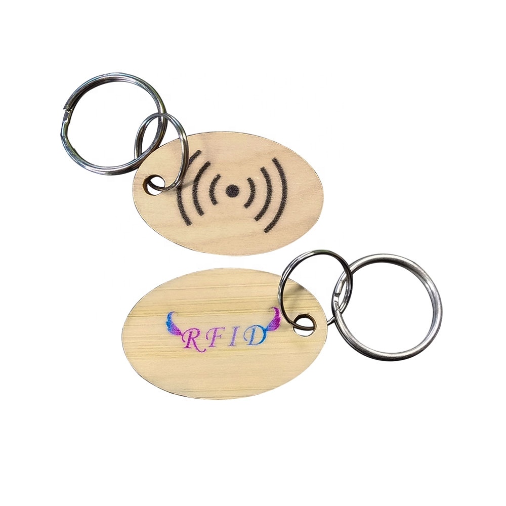 Set od dva ovalna drvena RFID priveska za ključeve ističe graviranje simbola talasa i štampanje RFID logotipa sa izdržljivim metalnim prstenovima za ključeve.