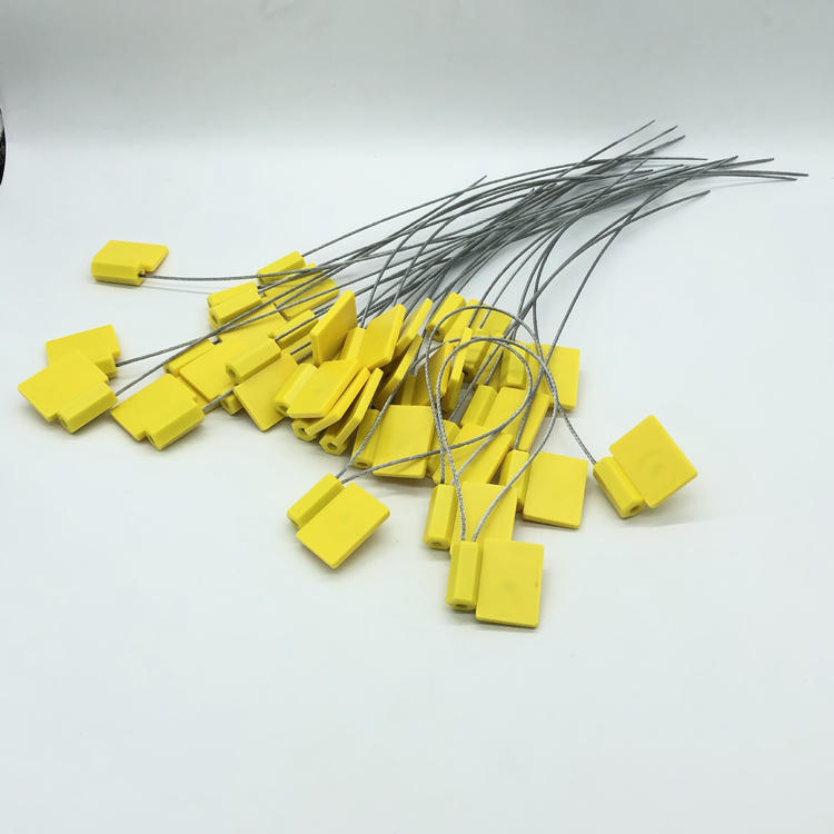 Više žutih SS3626-1 RFID sigurnosnih plombi je razbacano labavo, sa repovima od čelične žice koji se lepezasto šire po beloj pozadini.