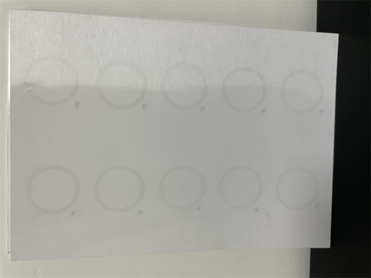 Krupni plan prelamiranog RFID lista sa antenskim umetkom koji prikazuje kružne prstenove antene poređane u redove za umetanje kartica.