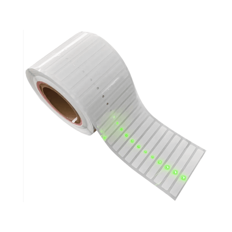 Studijska fotografija proizvoda prikazuje rolnu belih RFID LED etiketa sa jarkim zelenim svetlima upozorenja vidljivim na visećoj traci.