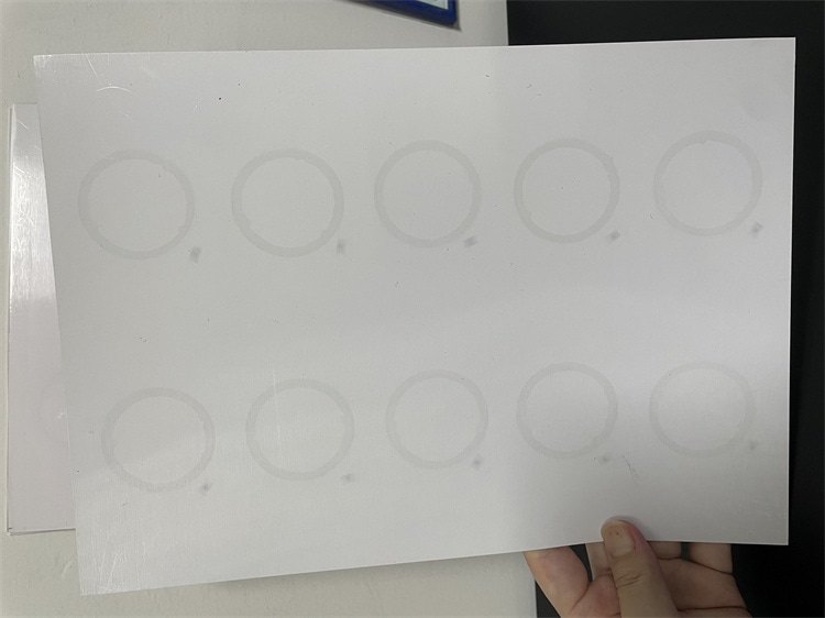 Ruka drži RFID prelam list sa antenskim umetkom sa pozicijama antenskog umetka kružne antene raspoređenim u rasporedu od dva reda.