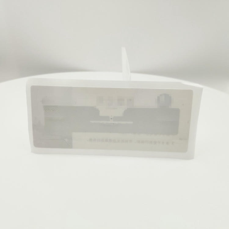 Prednji prikaz UHF RFID nalepnice za vetrobransko staklo na beloj podlozi ističe prozor inleja i oblik ivica za montažu sa unutrašnje strane stakla.