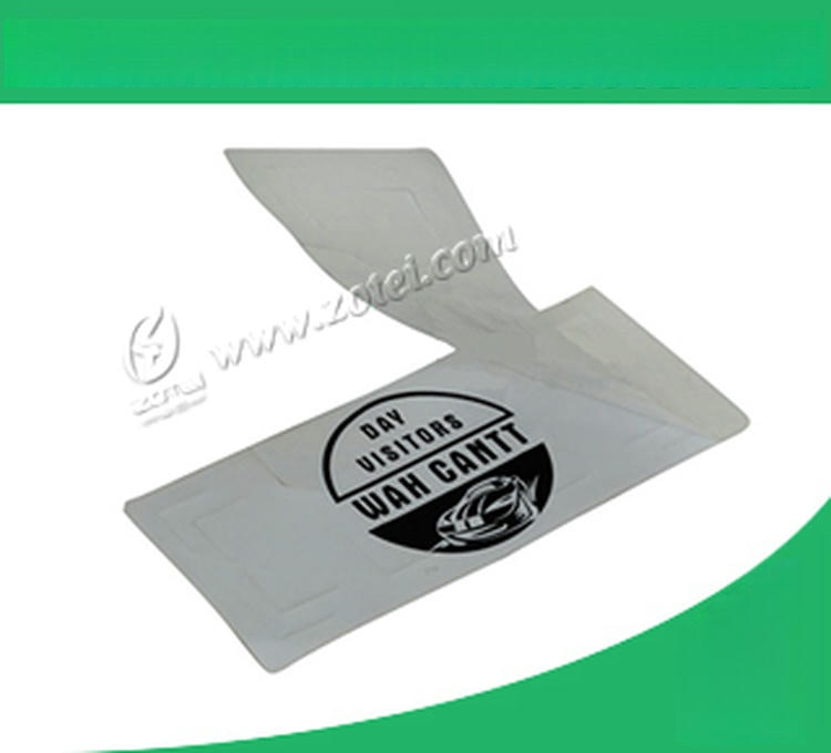 Uzorak RFID nalepnice za vetrobran delimično je odlepljen sa podloge i prikazuje lepljivu konstrukciju pristupne oznake za vozilo sa vidljivim tragovima skidanja.