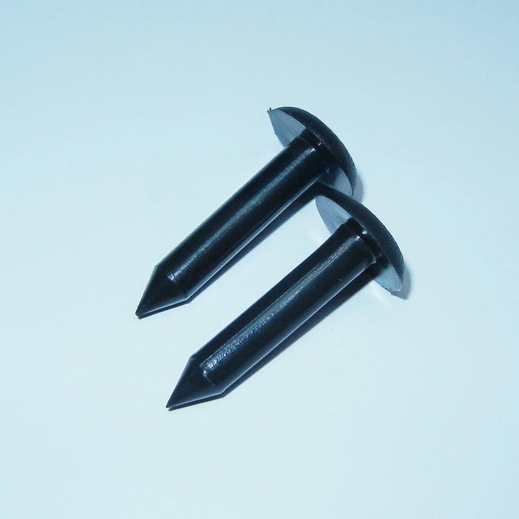 Slika prikazuje dve crne RFID oznake u obliku eksera NAIL06-5 u krupnom kadru proizvoda za identifikaciju drveća i označavanje šumske imovine.