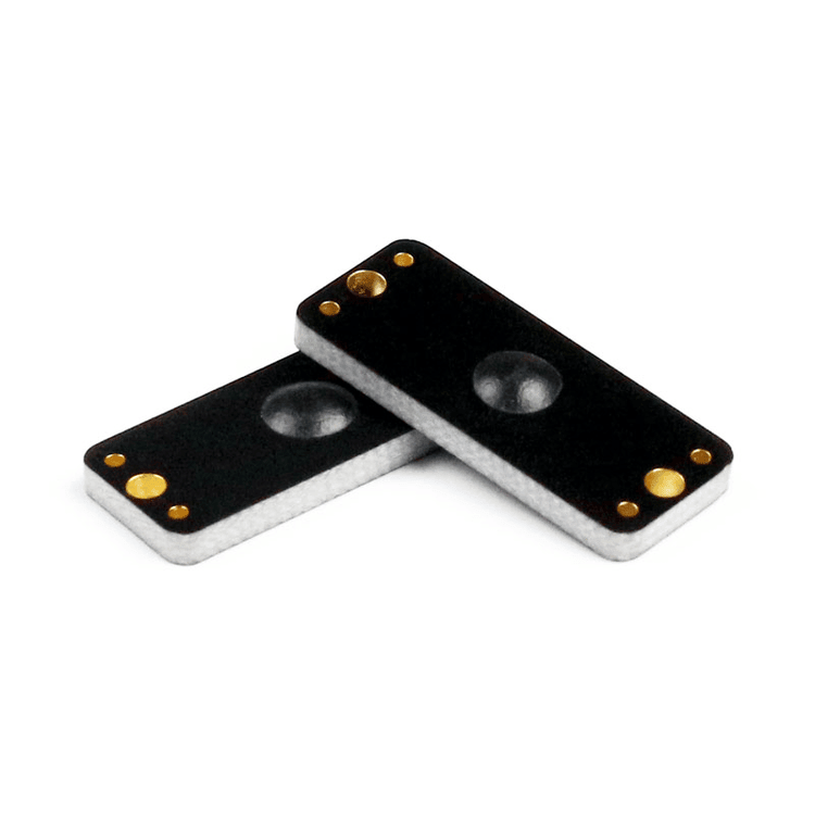 Krupni plan prikazuje dva P2510-1 PCB RFID taga za metalne površine koji se preklapaju kako bi istakli kupolasti centar i ojačane uglove.