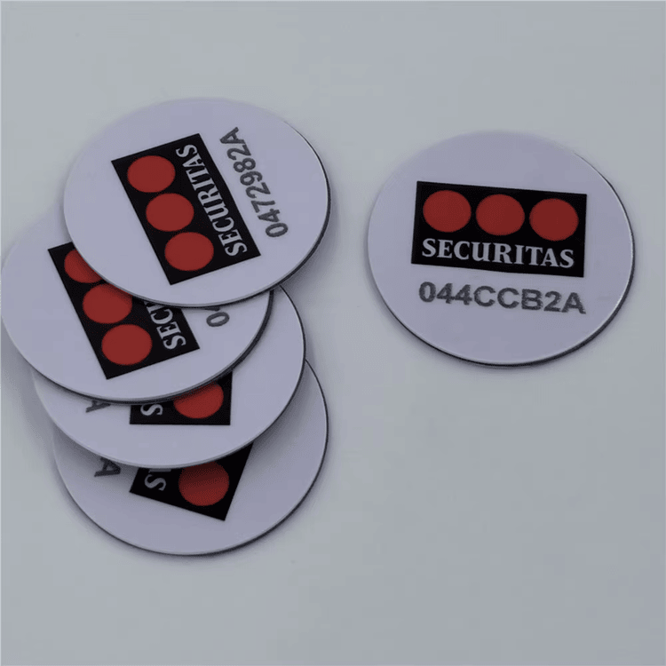 Štampani PVC RFID coin tagovi sa Securitas brendiranjem i serijskim kodovima demonstriraju identifikaciju za bezbednu kontrolu imovine.