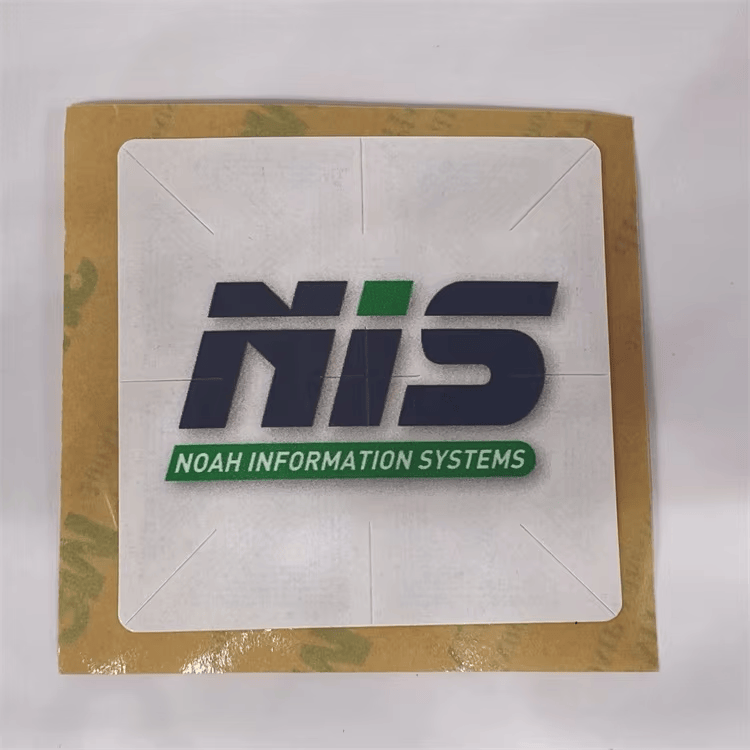 Krupni prikaz kvadratne RFID registracione nalepnice za vetrobran pokazuje logotip NIS na srebrnoj prednjoj strani s oznakama za poravnanje u uglovima.