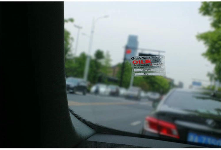 Pogled na put kroz vetrobransko staklo prikazuje statičku RFID nalepnicu za podsećanje o servisu postavljenu na staklo za obaveštenje o sledećoj poseti.