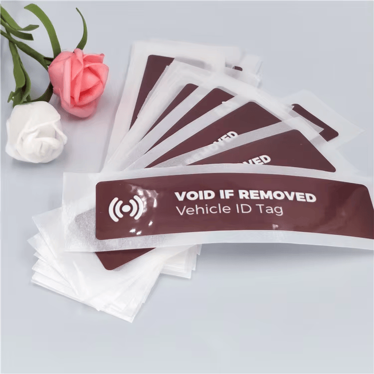 Lepezasto raspoređena pakovanja RFID etiketa za vetrobran koje pokazuju pokušaj uklanjanja prikazuju poruku VOID IF REMOVED za kontrolisani pristup vozila.
