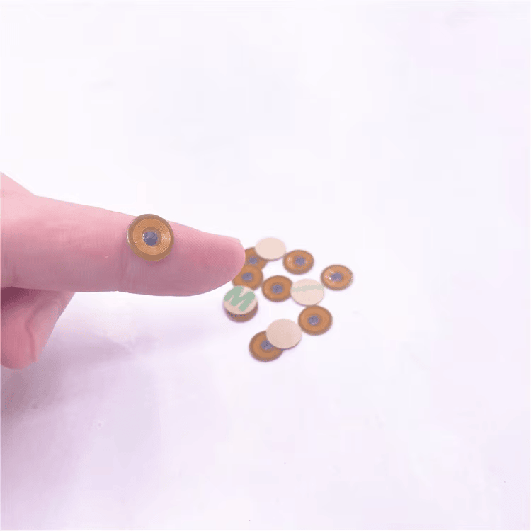 Mikro RFID oznaka FPC10-1 na prstu prikazuje sićušan okrugli FPC NFC umetak od 10mm namenjen identifikaciji na metalu.