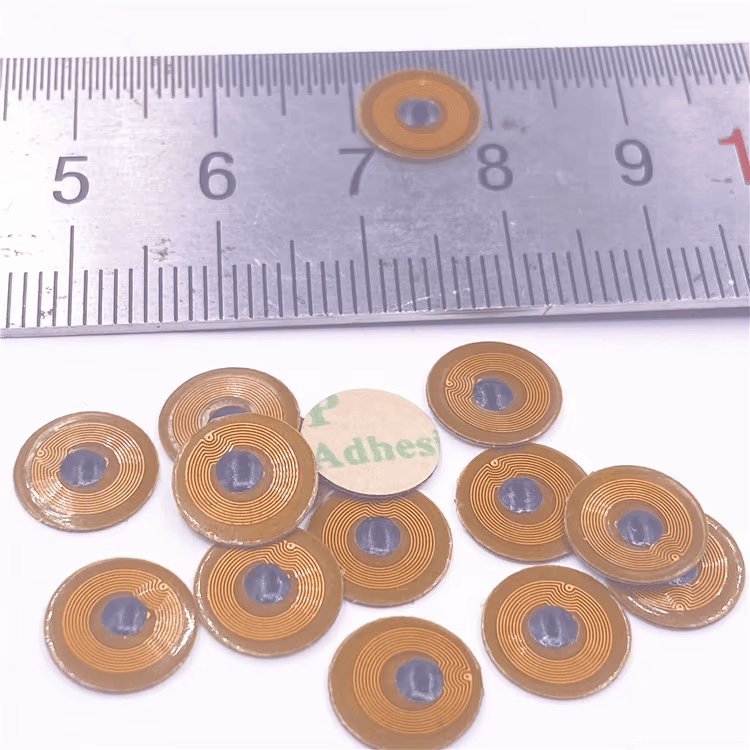 Lenjir i razbacane mikro NFC oznake FPC10-1 ilustruju kompaktan prečnik od 10mm i samolepljivu poleđinu koja se lako odlepljuje za metalnu imovinu.