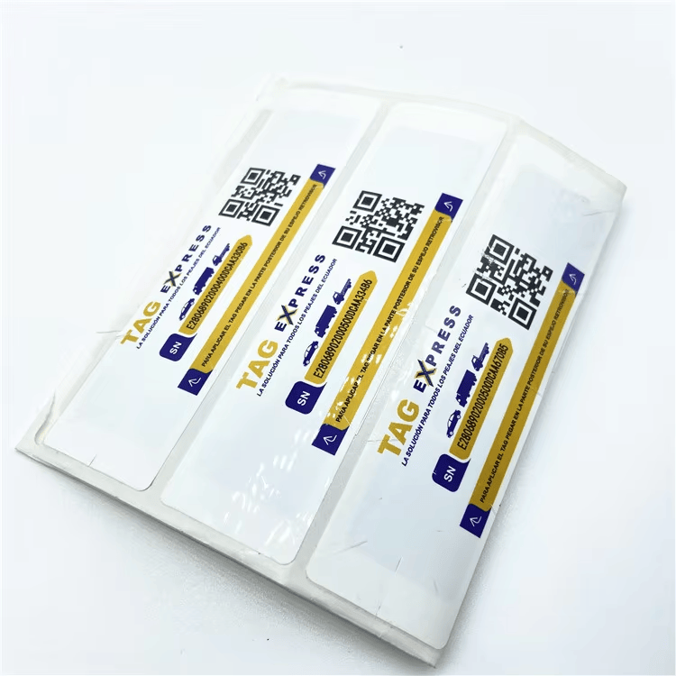 Tri UHF RFID nalepnice za pristup preko vetrobrana TAG EXPRESS postavljene su u providne omote kako bi se videla štampana serijska polja i QR kodovi.