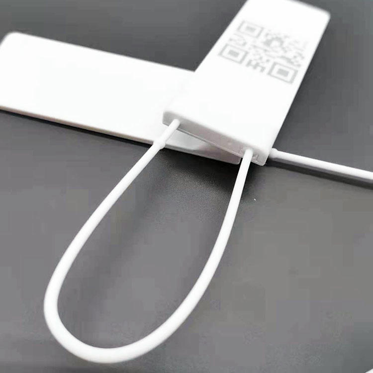 Detaljna slika izbliza fokusira se na deo za pričvršćivanje RFID platnene viseće oznake gde petlja prolazi kroz glavu oznake.