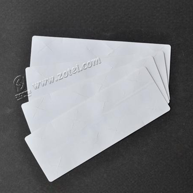 Izbliza prikazan složeni UHF RFID komplet za vetrobransko staklo na teksturiranom crnom materijalu naglašava glatku površinu za montažu.