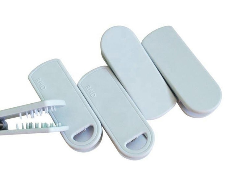 Ova slika prikazuje više delova SV-014 RFID clip taga, uključujući otvoreno telo klipa i prazne umetke za montažu.