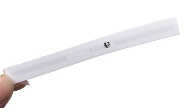 Jedna bela RFID LED etiketa sa podsetnikom drži se u ruci na svetloj pozadini kako bi se jasno prikazao dizajn dugačke uske trake.