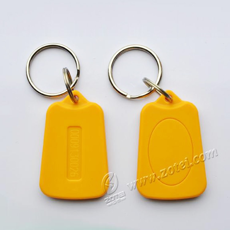 Jedan žuti ZT-SJZ-7 ABS RFID privezak sa metalnom alkom prikazuje svoj tanak profil dimenzija 39 × 25 × 5 mm.