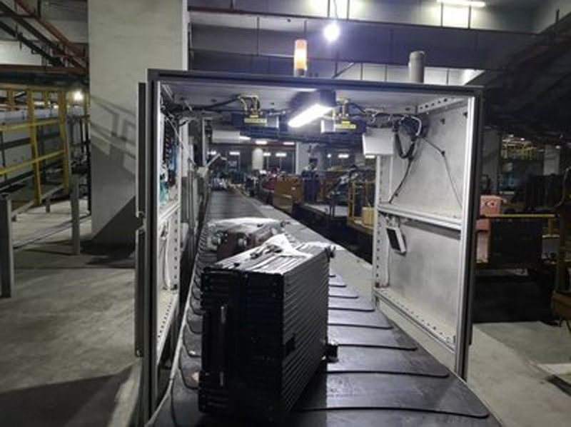 Scena implementacije fiksnog čitača prikazuje industrijsku opremu instaliranu duž transportne linije u fabričkom okruženju.