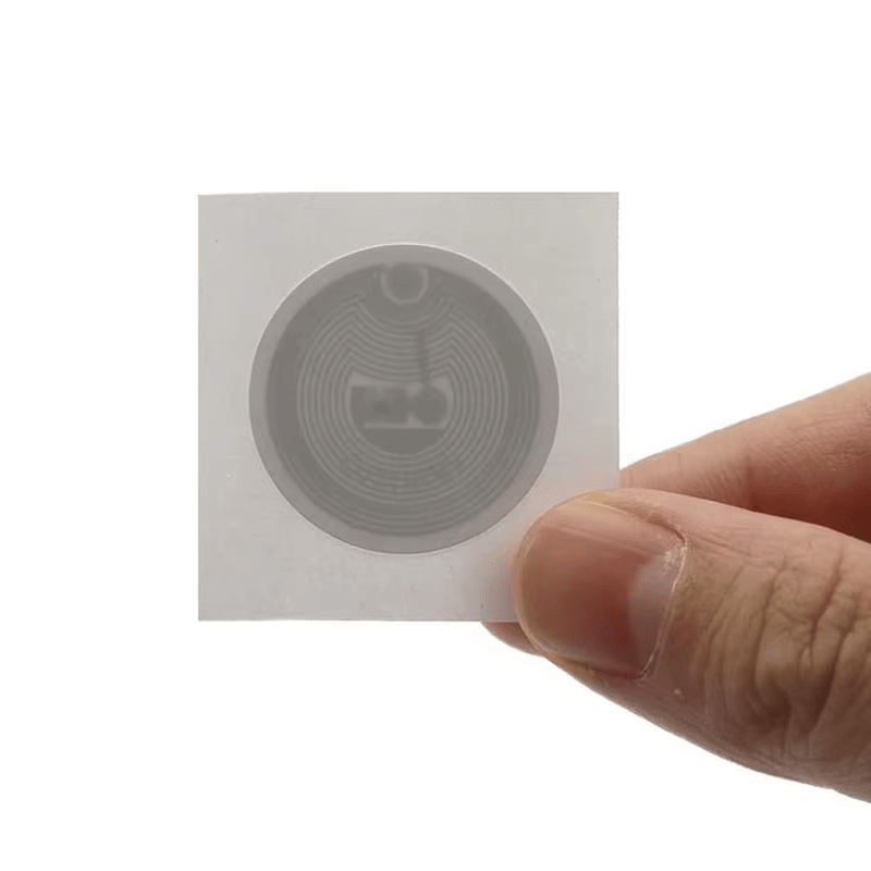 Ova detaljna ilustracija prikazuje različite funkcionalne slojeve HF RFID etikete, uključujući štampanu površinu i kvalitetnu samolepljivu podlogu.