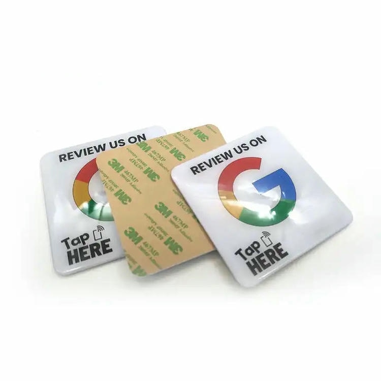 Četvrtaste NFC nalepnice od epoksidne smole prikazane su sa zaštitnim papirom na samolepljivoj podlozi za brzo postavljanje na kartone kontejnere i oznake lokacija u skladištu.