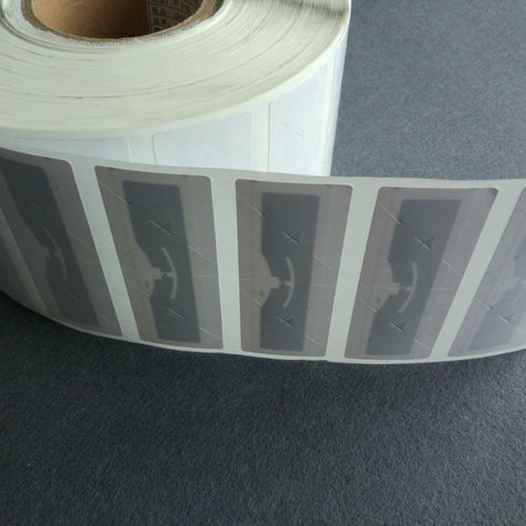 Neprekidna rolna UHF RFID umetaka etiketa za vetrobran prikazana je na nosećoj traci za masovnu primenu u naplati putarine.